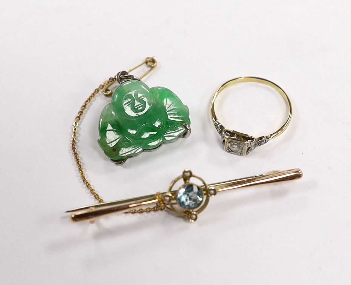 An Edwardian 9ct, aquamarine and seed pearl cluster set bar brooch, 54mm, a Chinese mounted jade Buddha pendant and an 18ct and single stone diamond set ring, with diamond chip set shoulders.